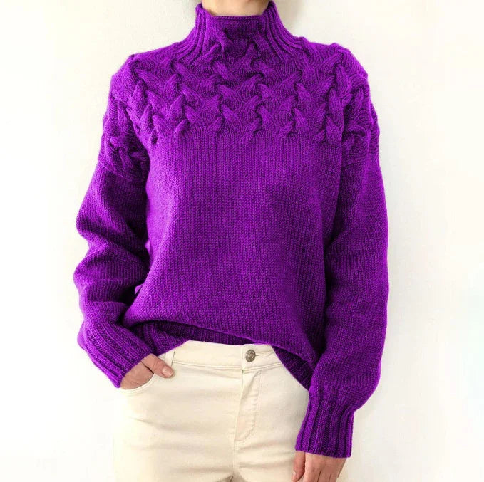 Purple knitted turtleneck sweater with cable knit pattern, worn with cream pants