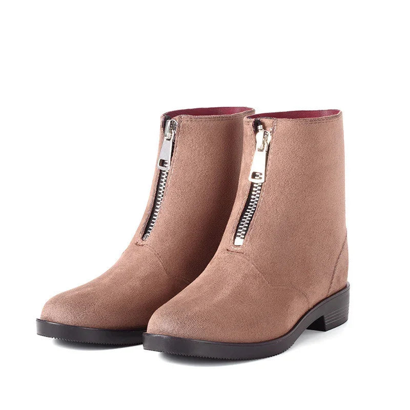 Taupe suede ankle boots with front silver zipper and black low heel on white background