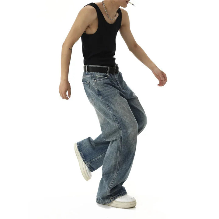 Person wearing black tank top, baggy blue jeans, white sneakers, silver chain necklace on white background