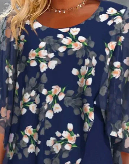 Navy blue floral dress with pink and white flowers and bell sleeves, worn with star necklace