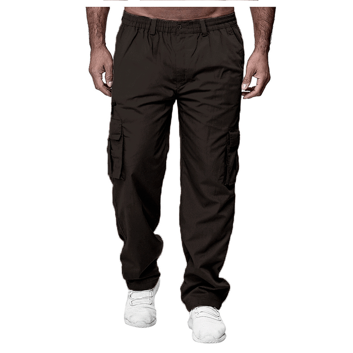 Men's black cargo pants with multiple pockets worn with white sneakers on white background