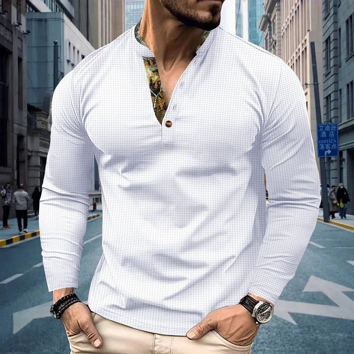 Man wearing white long-sleeve henley shirt with floral print placket in urban street setting