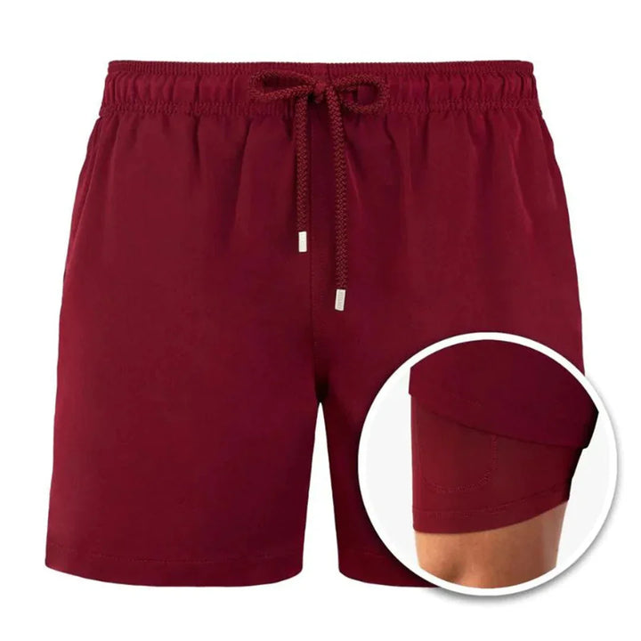 Maroon men's athletic shorts with elastic waistband and inner compression liner close-up