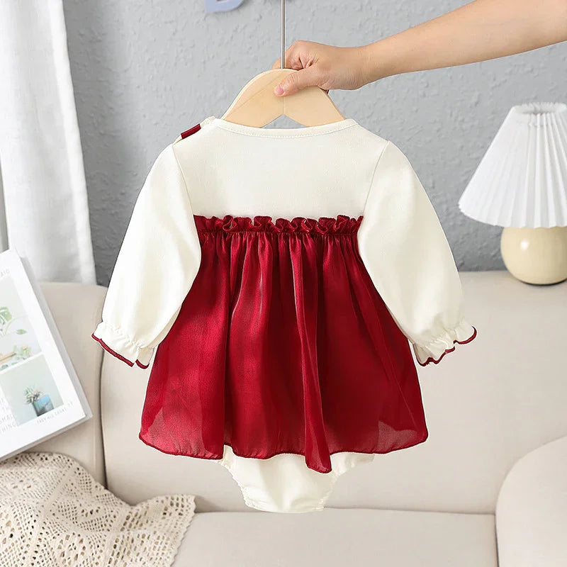 Baby girl long sleeve dress with cream top and red gathered skirt held on wooden hanger