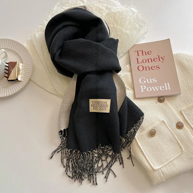 Black and beige fringed scarf with label, cream knit jacket with buttons, book titled The Lonely Ones by Gus Powell, hair clip on plate