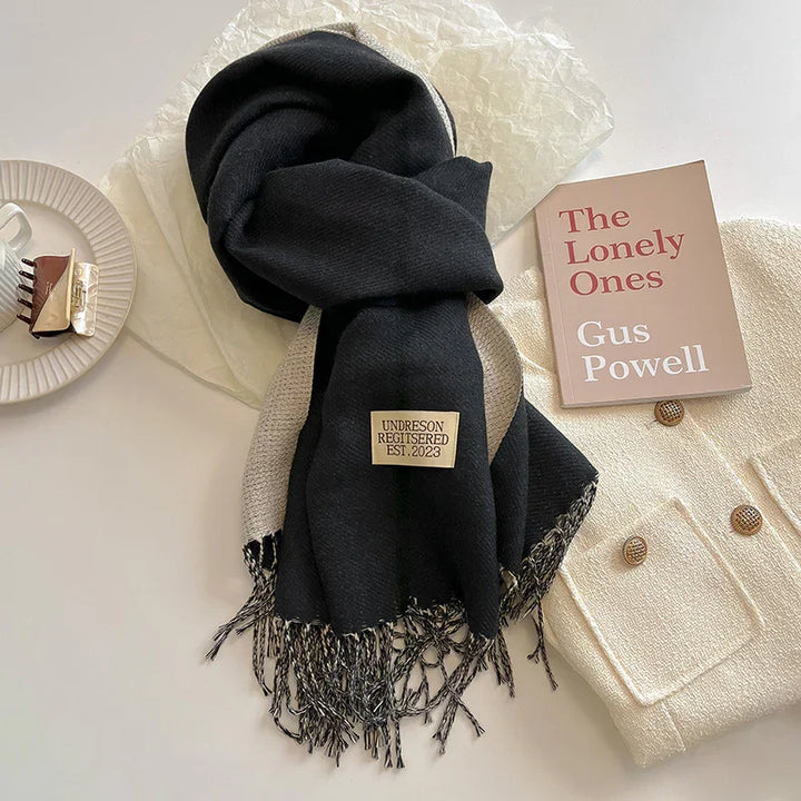 Black and beige fringed scarf with label, cream knit jacket with buttons, book titled The Lonely Ones by Gus Powell, hair clip on plate