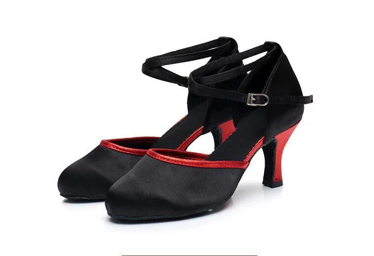 Black and red high-heeled dance shoes with ankle straps on white background