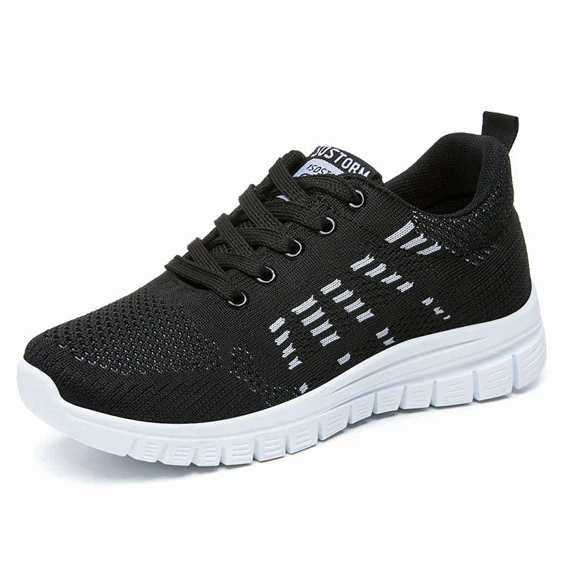 Black knit athletic sneaker with white patterned accents and thick white sole, black laces