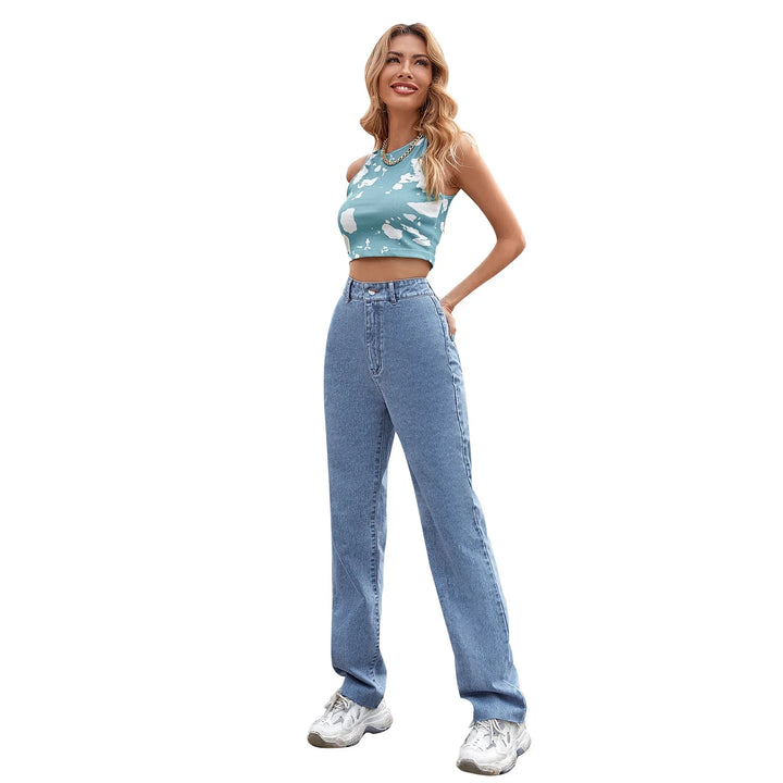 woman wearing blue tie-dye crop top, high-waisted jeans, and white sneakers on white background