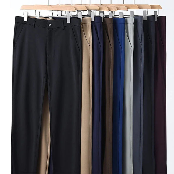 Nine pairs of formal trousers in black, beige, navy, brown, blue, gray, and maroon on wooden hangers