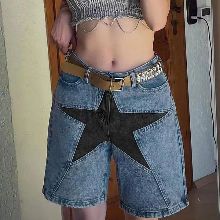 Woman wearing high-waisted acid wash denim shorts with a large black star design and two-tone belt