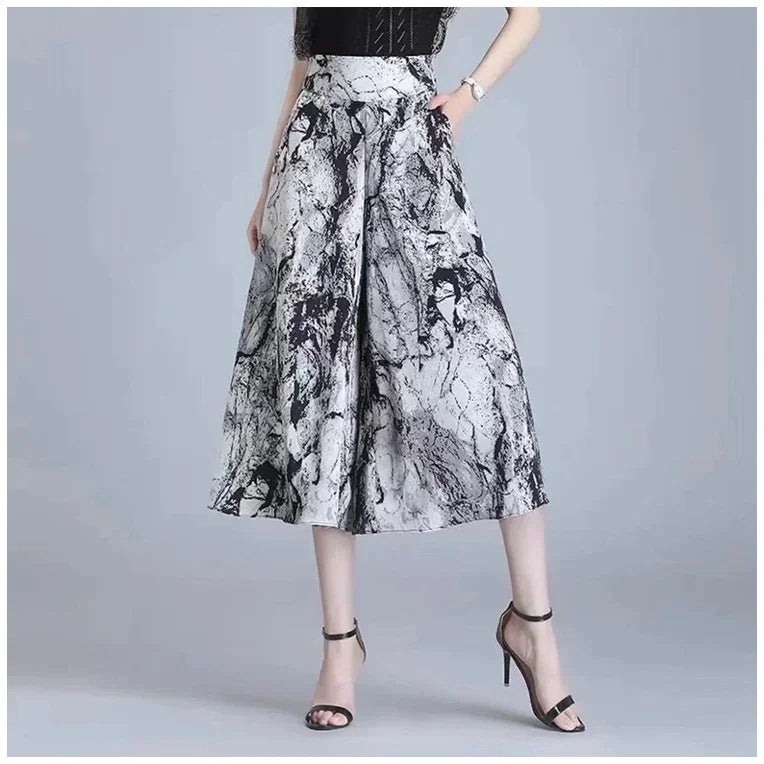 Women's high-waisted, wide-leg pants with black and white marble print, paired with black high-heeled sandals