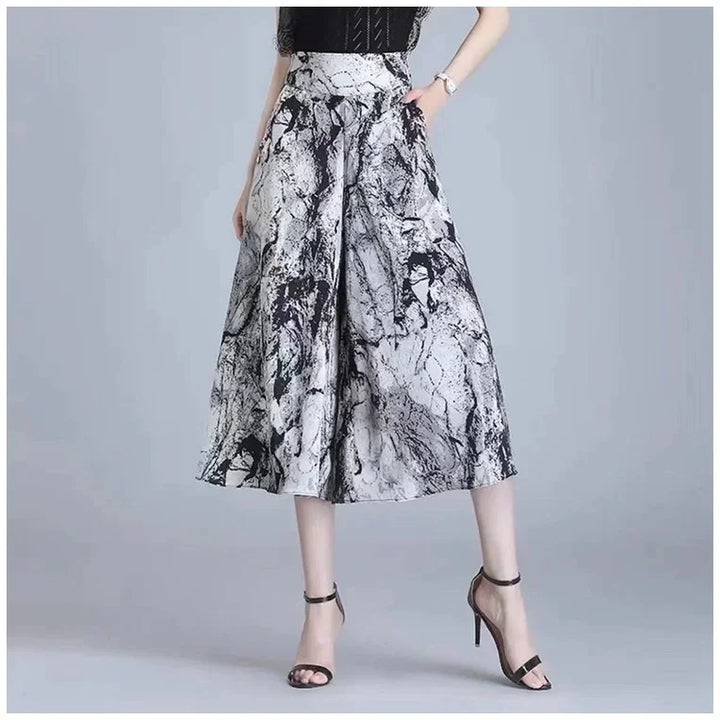 Women's high-waisted, wide-leg pants with black and white marble print, paired with black high-heeled sandals