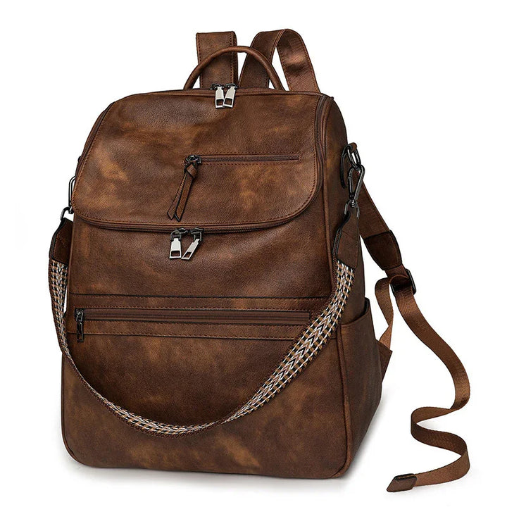 brown leather backpack with multiple zip pockets and braided shoulder strap on white background