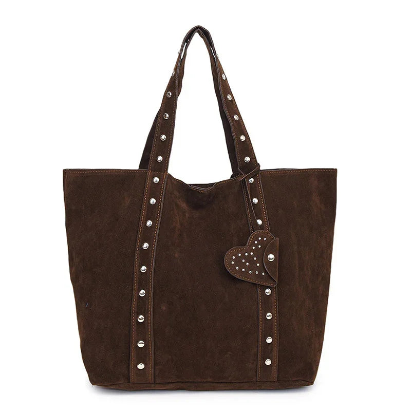 Brown suede tote bag with studded handles and heart-shaped studded charm