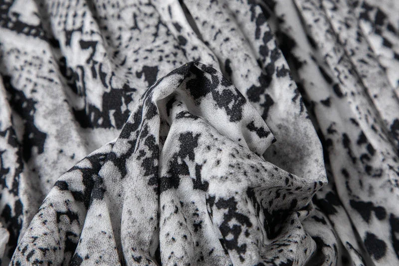 Close-up of black and white abstract patterned fabric with soft folds and texture