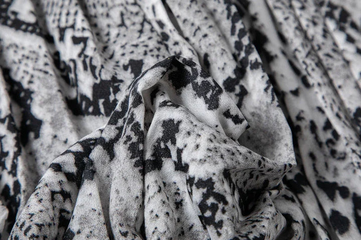 Close-up of black and white abstract patterned fabric with soft folds and texture