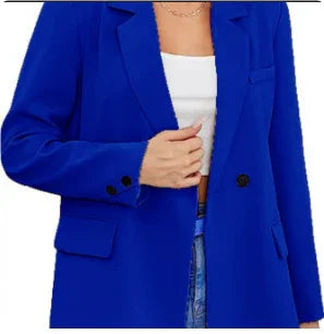 Woman wearing a vibrant blue blazer and white top, cropped at waist, fashion portrait