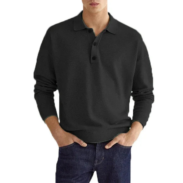 Man wearing black long-sleeve polo shirt paired with dark blue jeans in casual pose