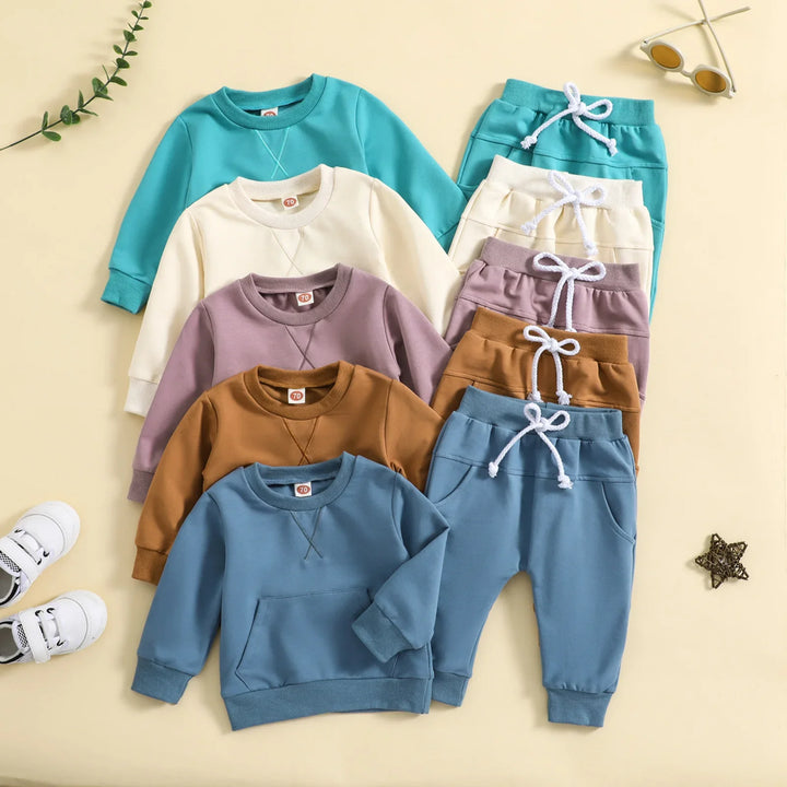 Five sets of colorful toddler sweatshirts and pants in blue, brown, purple, cream, and teal with white drawstrings