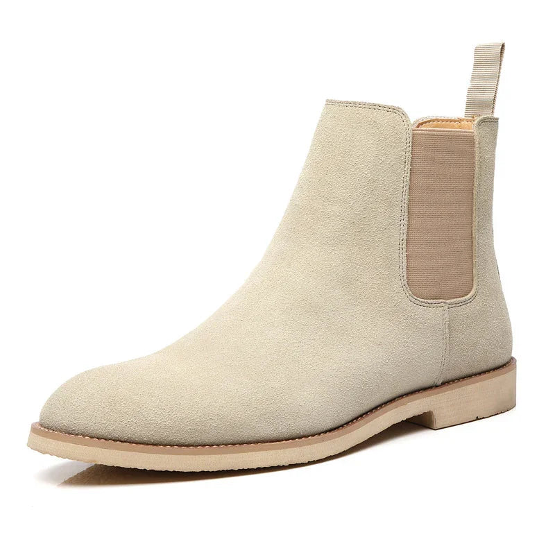 Beige suede Chelsea boot with elastic side panels and light rubber sole on white background