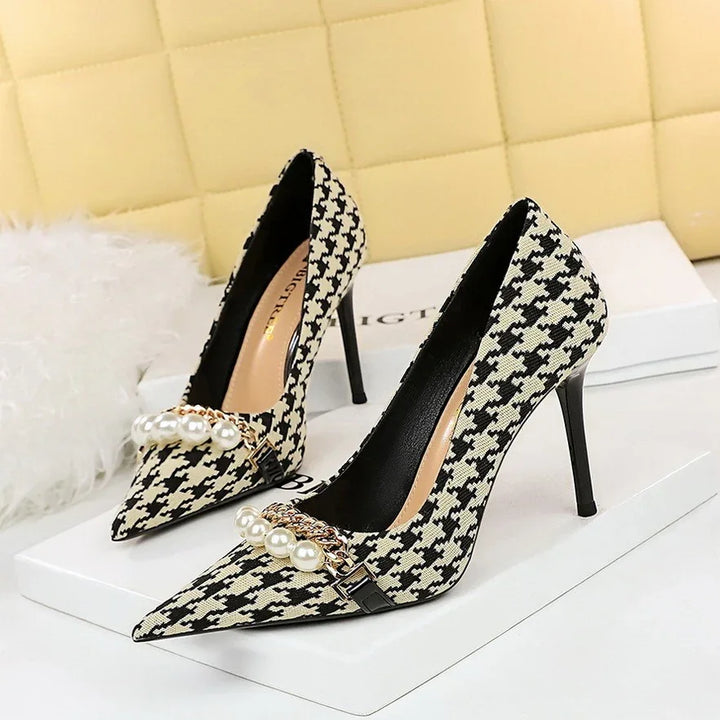 Elegant women's high heels with black and white houndstooth pattern and pearl chain detail