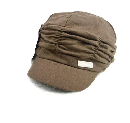 brown ruched fabric cap with small metal tag reading 'FASHION' on front visor