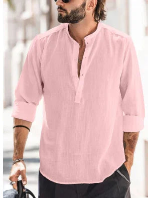 Man wearing light pink mandarin collar casual shirt with rolled-up sleeves and black pants