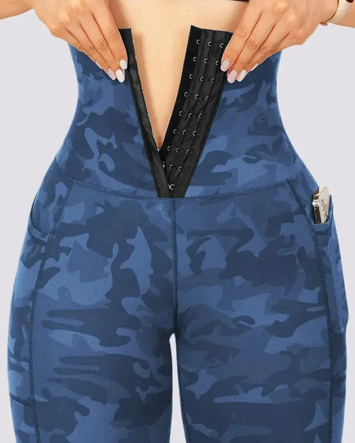 Woman wearing blue camo high-waist leggings with front hook-and-eye closure and side pocket