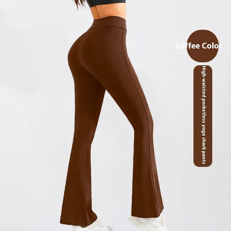 Woman wearing coffee color high-waisted pocketless yoga shark pants with flared legs and white sneakers