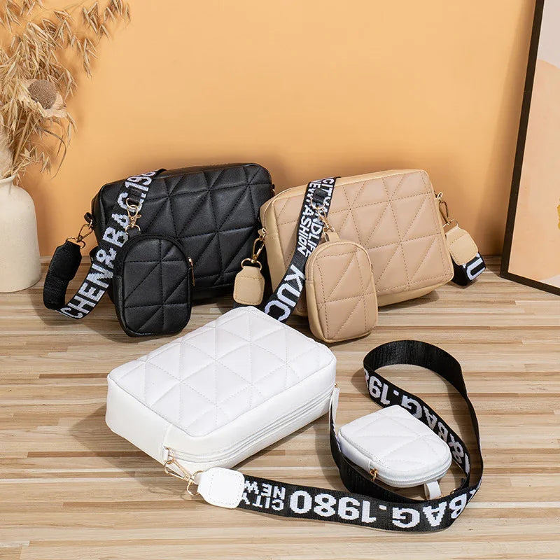 Three quilted crossbody bags in black, beige, and white with detachable pouches and wide black straps with white text on wooden surface