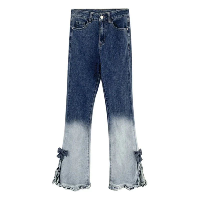 Dark blue to light faded ombre denim jeans with flared legs and bow accents at the hem