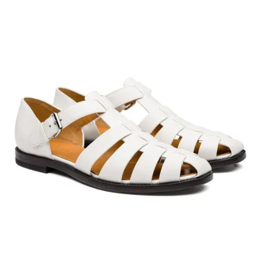 White leather fisherman sandals with buckle strap and black soles on white background