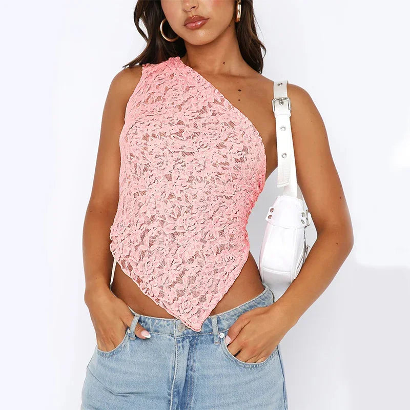 Woman wearing pink floral lace one-shoulder asymmetrical crop top with light blue denim jeans and white shoulder bag