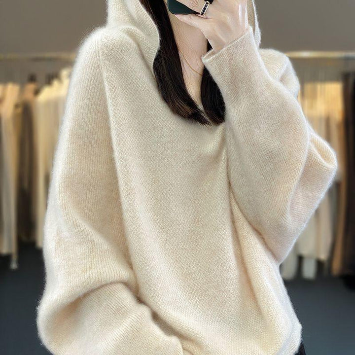 Woman wearing a cozy oversized cream knit sweater with long sleeves indoors