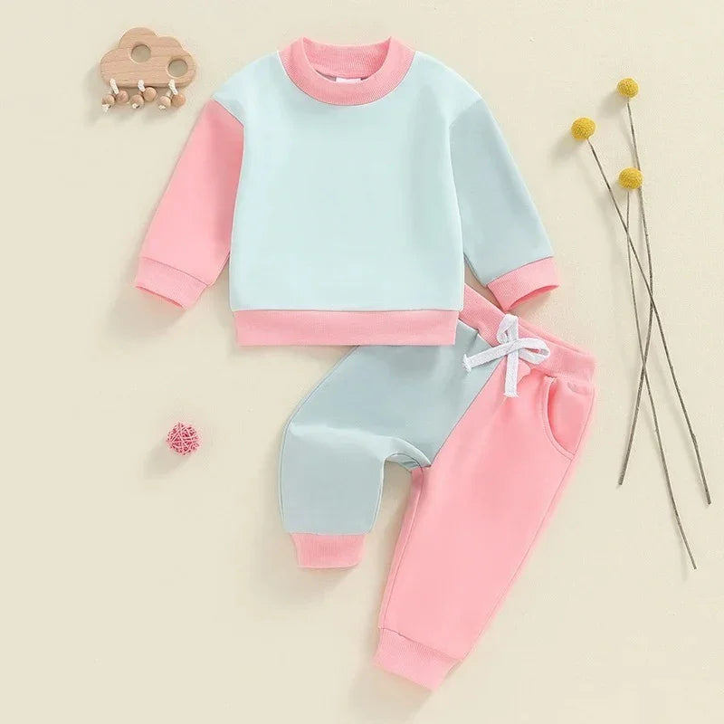 Two-piece baby outfit with pastel pink and blue long-sleeve top and matching pants with white drawstring