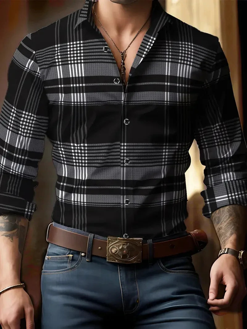 Man wearing black and gray plaid button-up shirt with rolled sleeves, blue jeans, brown belt, and necklace
