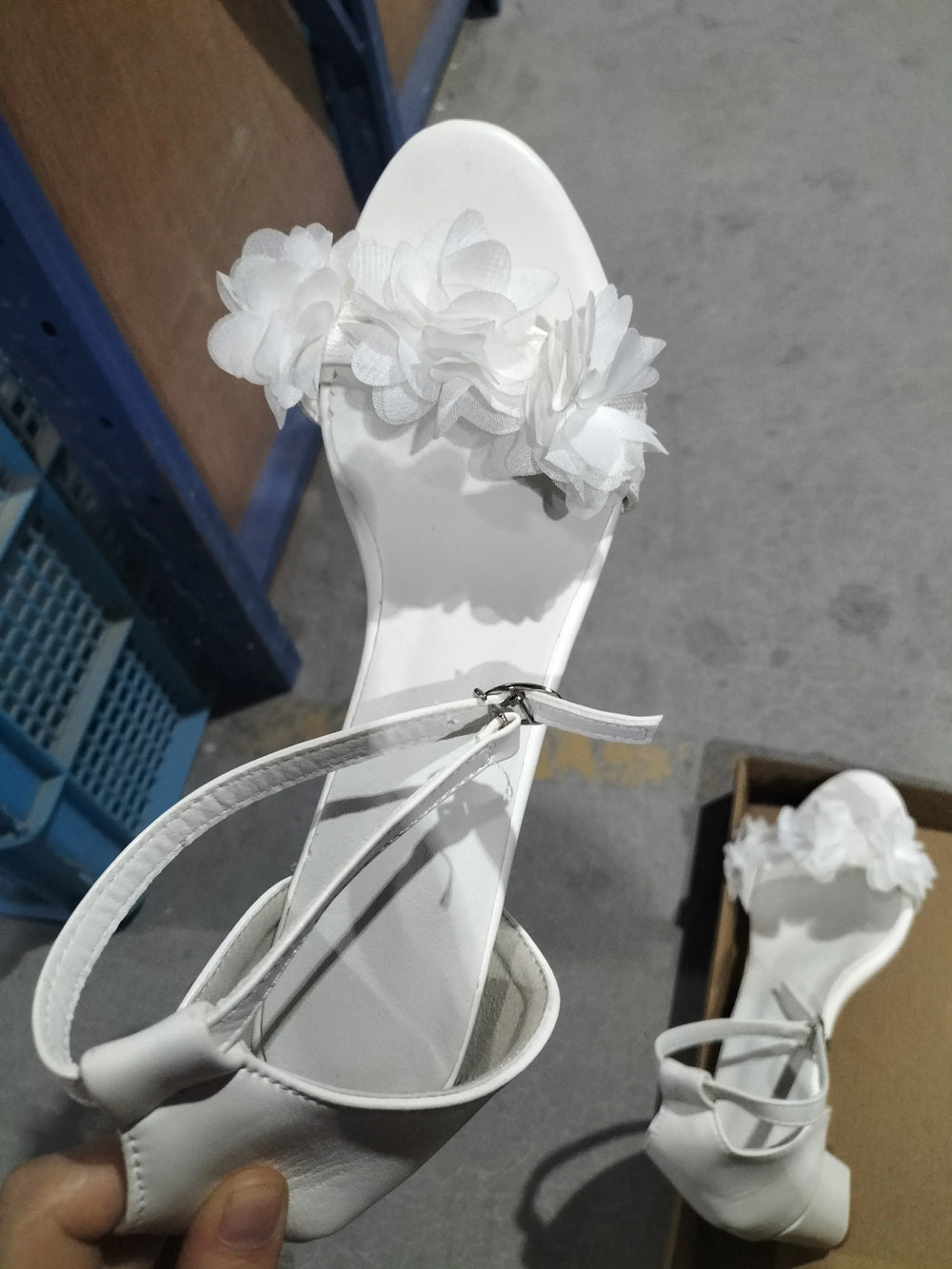 White women's sandals with ankle strap and decorative fabric flowers on front strap