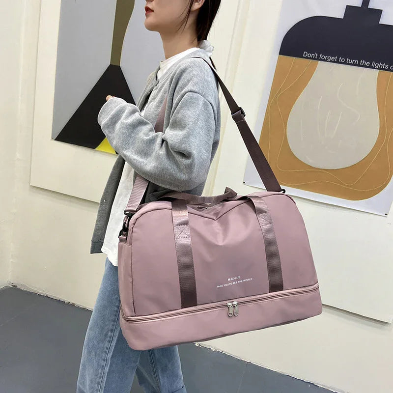 Woman in casual outfit carrying large pink travel duffel bag with shoulder strap indoors