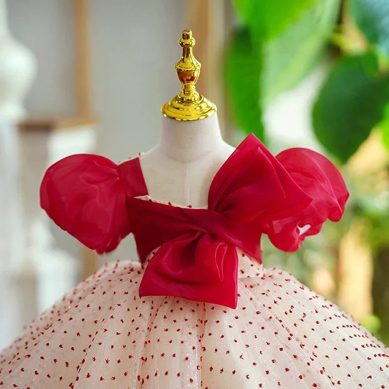 Elegant red and white toddler dress with a large bow and puff sleeves on a mannequin