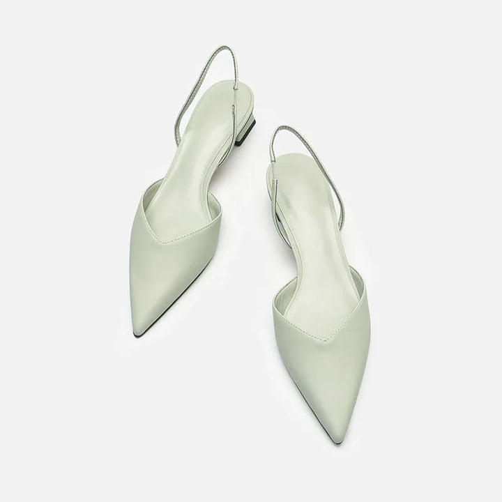 Pair of white pointed toe slingback flat shoes on a white background