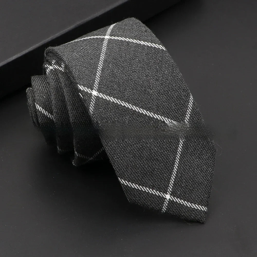 Rolled dark gray men's necktie with white checkered pattern on black background