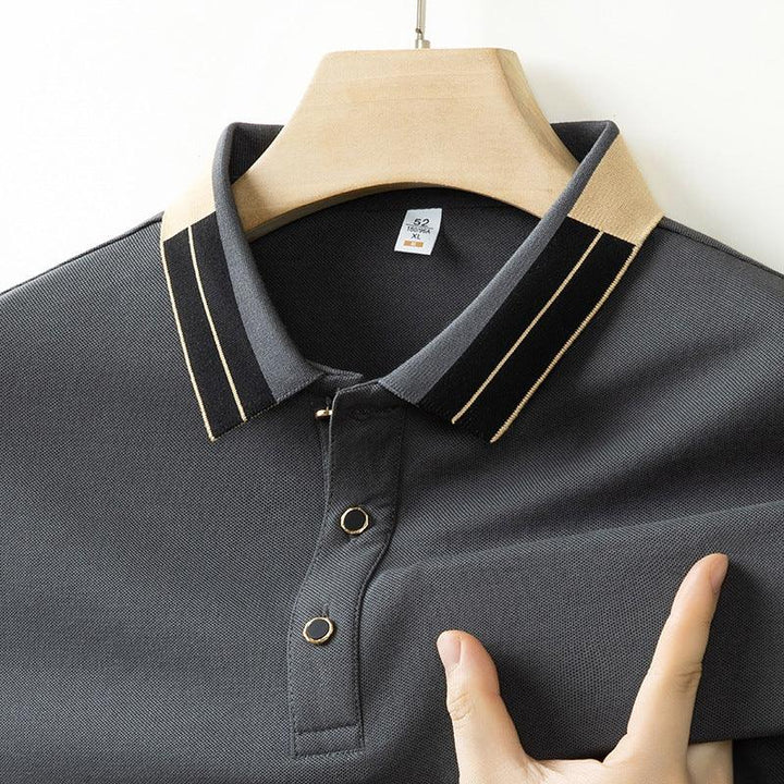 Close-up of dark gray polo shirt with beige and black striped collar on wooden hanger