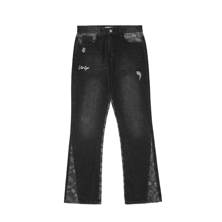 Black distressed jeans with paisley pattern panels and white script detail on left thigh
