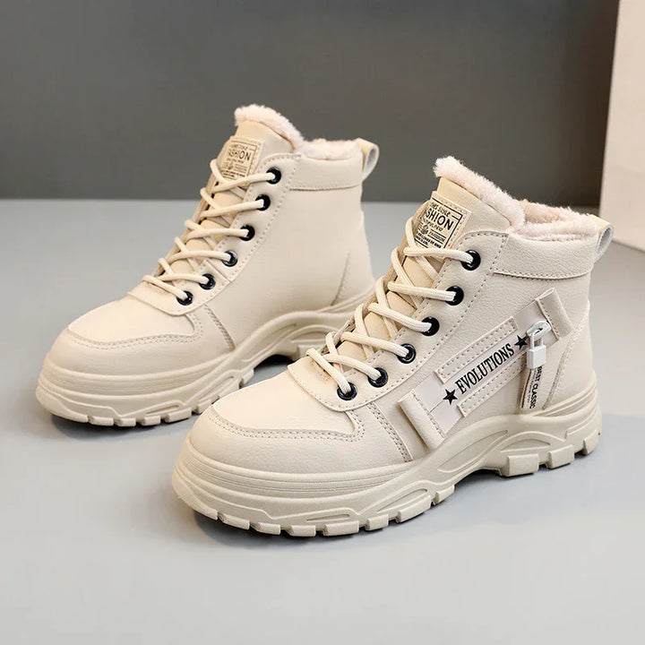 Beige winter boots with fur lining, lace-up design, zipper detail, and chunky sole on gray surface