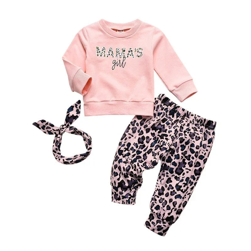 Baby girl clothing set with pink sweatshirt reading Mamas girl, leopard print pants, and matching headband