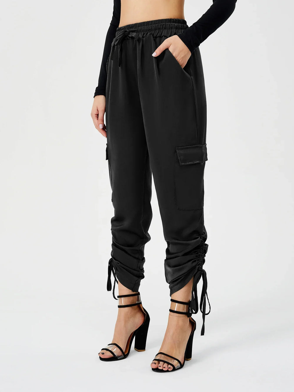 Woman wearing black cargo jogger pants with drawstring details and black high heel sandals