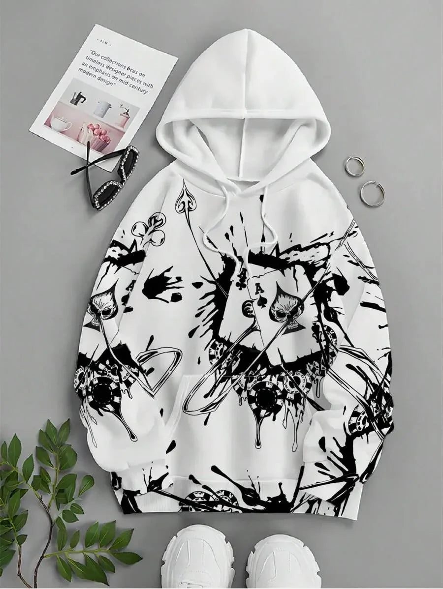 White hoodie with black ink splatter and playing card designs, styled with sunglasses, hoop earrings, and sneakers
