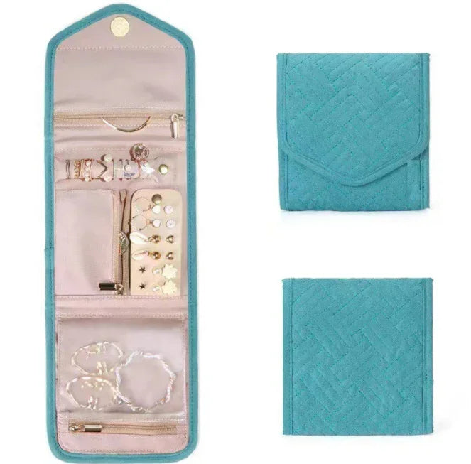 Teal quilted foldable jewelry organizer with compartments, zippers, and assorted earrings and bracelets