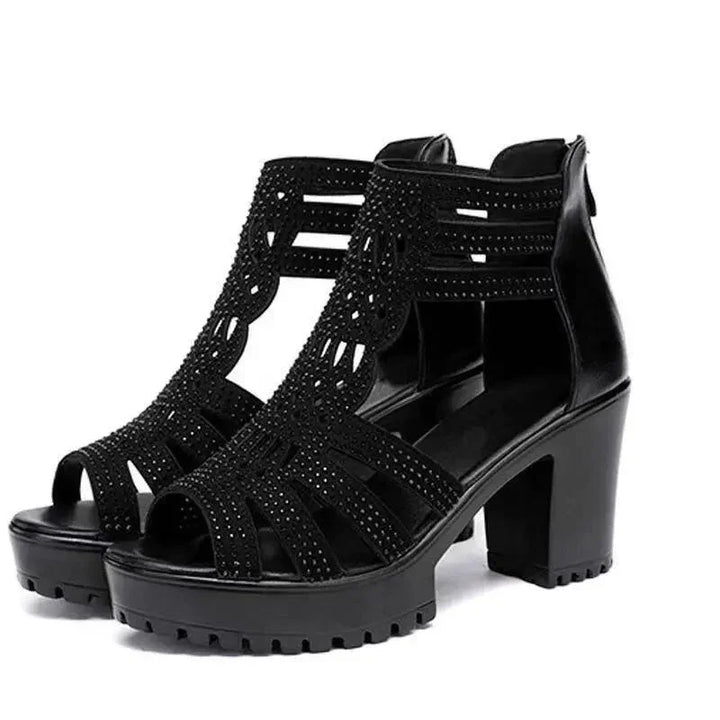 Black high-heeled platform sandals with strappy cutout design and studded embellishments